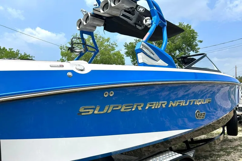 Slide: The Image of 2013 Nautique Super Air Nautique G23 boat in vibrant blue, side view. - 8