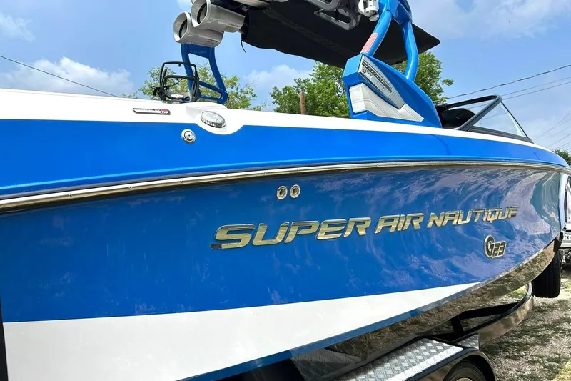 Slide: The Image of 2013 Nautique Super Air Nautique G23 boat, blue and white, side view. - 9