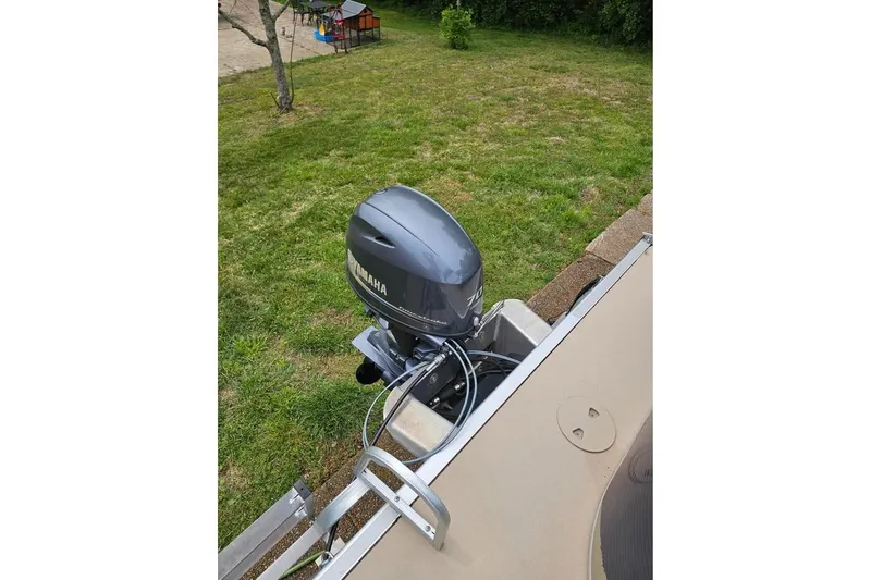 Slide: The Image of 2012 Sweetwater 20sf boat with Yamaha outboard motor in grassy area. - 2