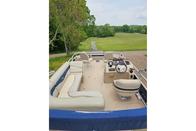 Slide: The Image of 2012 Sweetwater 20sf pontoon boat interior with beige seating and steering console. - 4