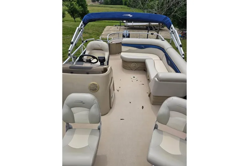 Slide: The Image of 2012 Sweetwater 20sf pontoon boat interior with beige seating and blue canopy. - 9