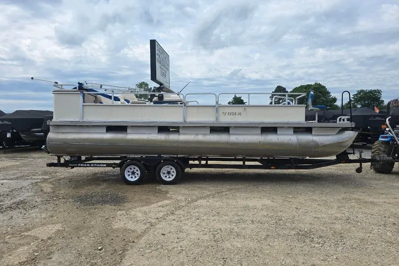 The Image of 2003 Sun Tracker Party Barge 24 pontoon boat on trailer, parked outdoors. - 1