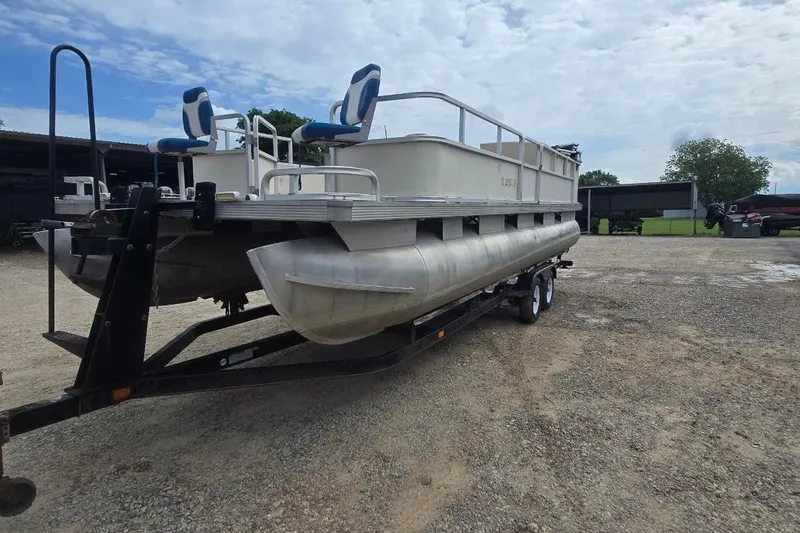 Slide: The Image of 2003 Sun Tracker Party Barge 24 pontoon boat on trailer, parked outdoors. - 3