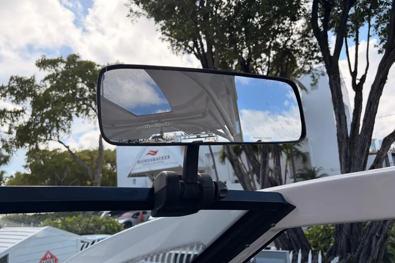 Slide: The Image of Rearview mirror on 2021 Yamaha Boats 275SD, reflecting sky and trees. - 25