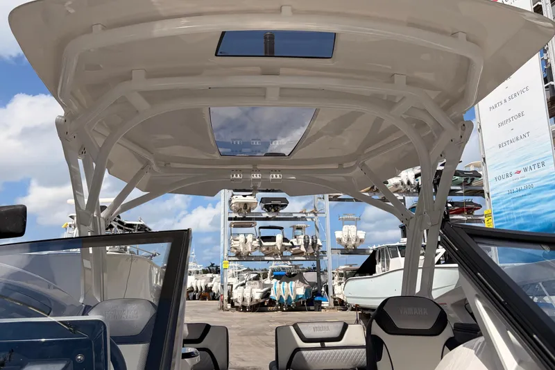 Slide: The Image of 2021 Yamaha Boats 275SD interior view with marina backdrop. - 27