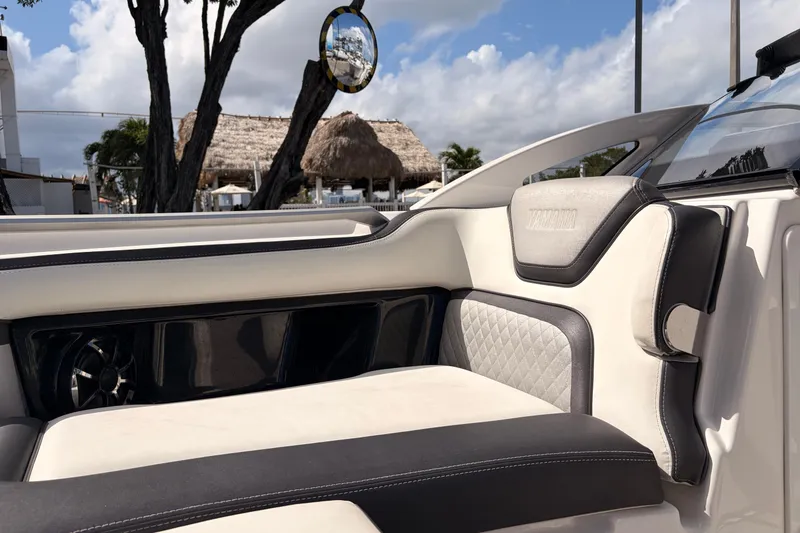 Slide: The Image of 2021 Yamaha Boats 275SD interior with luxurious seating and speaker, tropical background. - 33
