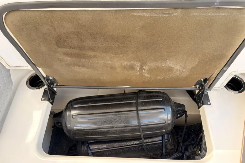 Slide: The Image of Open storage compartment on 2021 Yamaha Boats 275SD, showing a black fender and ropes. - 41