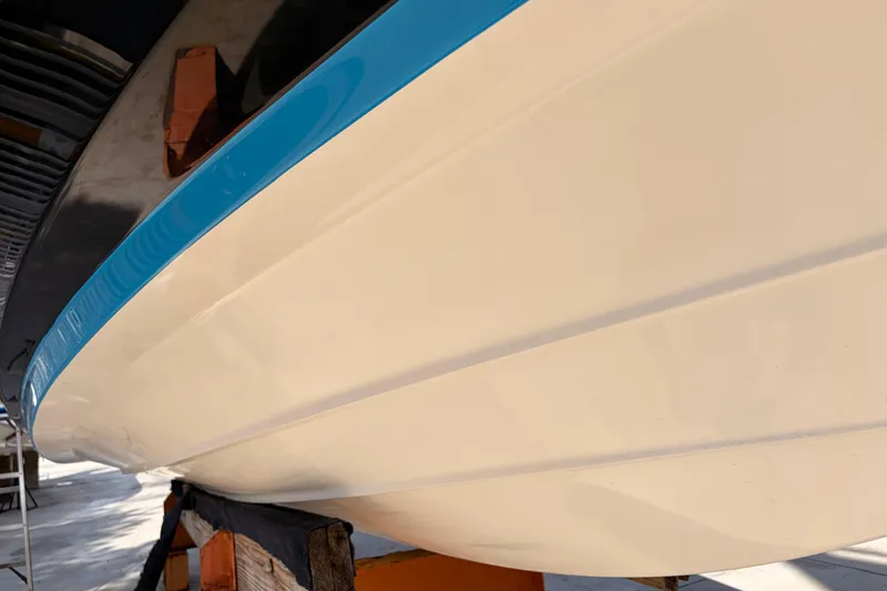 Slide: The Image of 2021 Yamaha Boats 275SD hull with blue stripe, displayed on supports. - 49