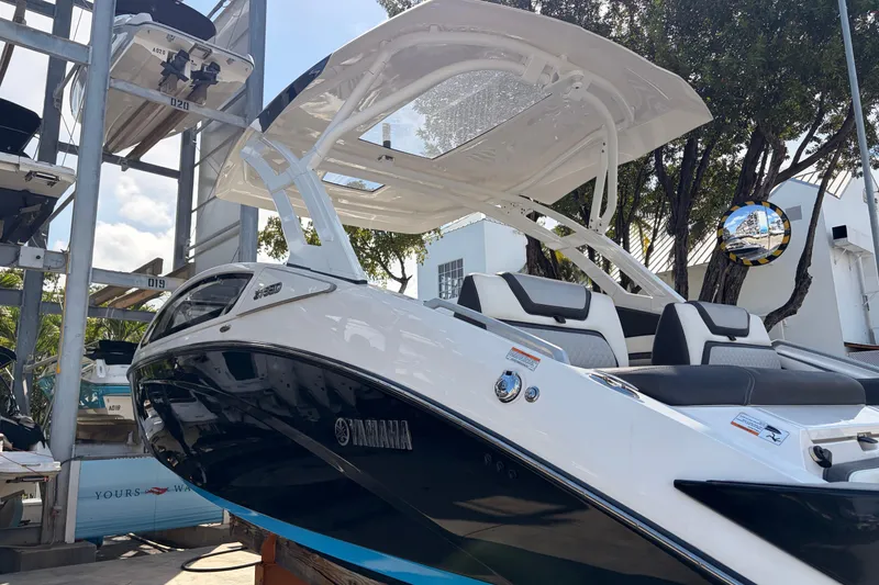 Slide: The Image of 2021 Yamaha Boats 275SD with sleek design and modern seating, docked outdoors. - 5