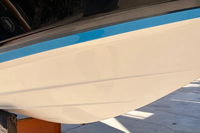 Slide: The Image of 2021 Yamaha Boats 275SD hull with blue accent, displayed outdoors. - 50