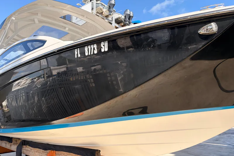 Slide: The Image of 2021 Yamaha Boats 275SD with sleek black hull, docked under clear blue sky. - 51