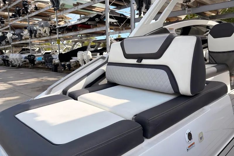 Slide: The Image of 2021 Yamaha Boats 275SD with luxurious seating in a marina storage area. - 8
