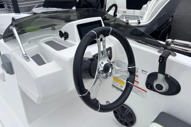 Slide: The Image of 2024 Tahoe T18 boat dashboard with steering wheel and control panel. - 2
