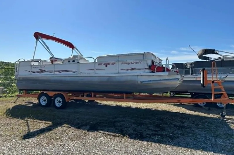 The Image of 1999 PlayCraft Sport 2400 pontoon boat on trailer, sunny day, outdoor setting. - 1
