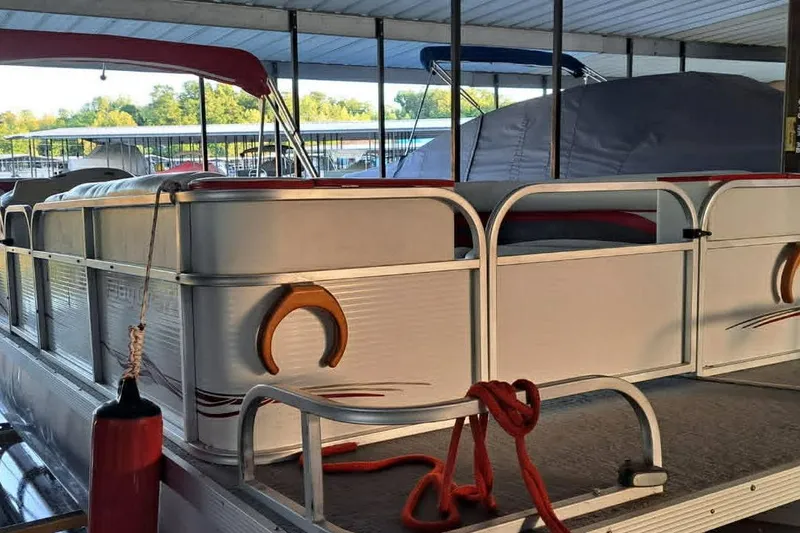 Slide: The Image of 1999 PlayCraft Sport 2400 pontoon boat docked with red canopy and ropes. - 10