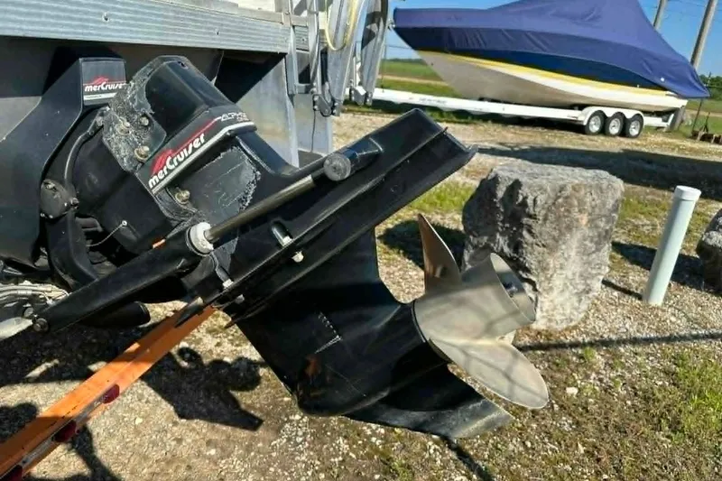 Slide: The Image of 1999 PlayCraft Sport 2400 boat with MerCruiser outdrive, parked on gravel. - 2