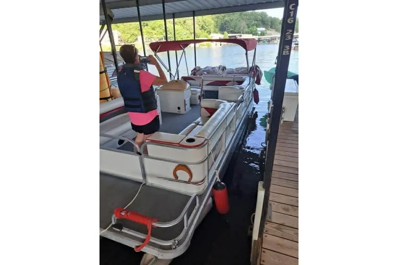 Slide: The Image of Person on 1999 PlayCraft Sport 2400 pontoon boat at dock, wearing a life vest. - 3