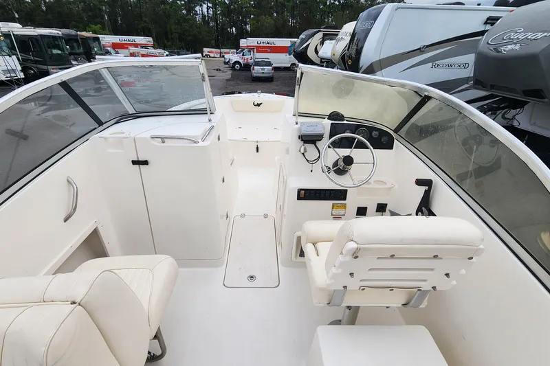 Slide: The Image of 2006 Mako 216 Dual Console boat interior with steering wheel and seating. - 10