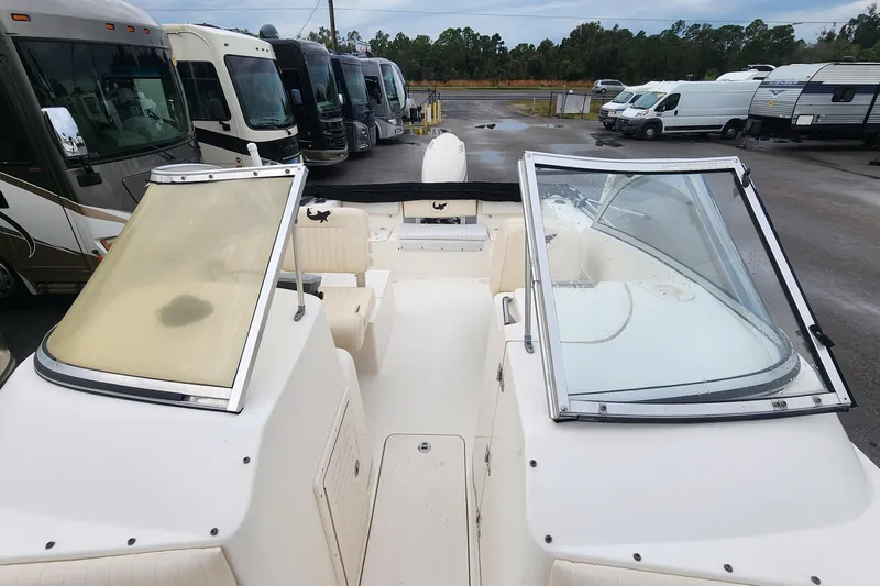 Slide: The Image of 2006 Mako 216 Dual Console boat interior with open windshield, parked near RVs. - 12