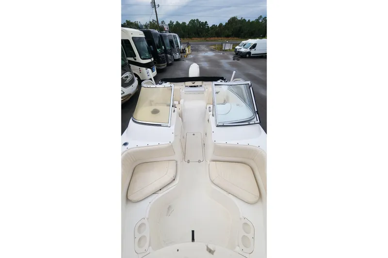 Slide: The Image of 2006 Mako 216 Dual Console boat interior with seating and windshield, parked near RVs. - 13