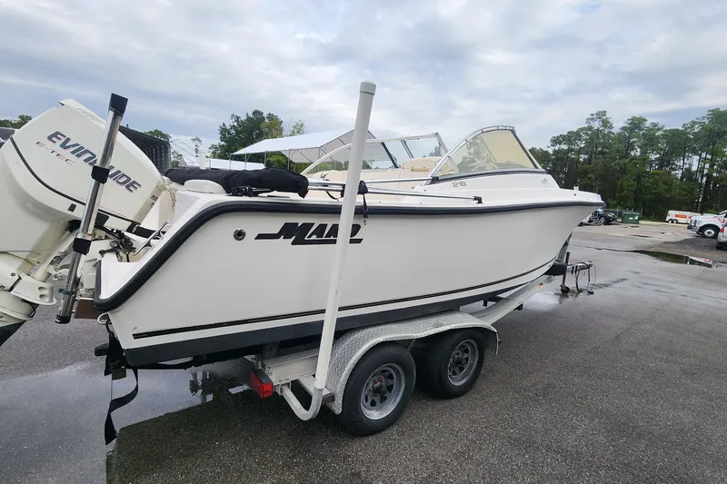 Slide: The Image of 2006 Mako 216 Dual Console boat on trailer with Evinrude engine in parking lot. - 3