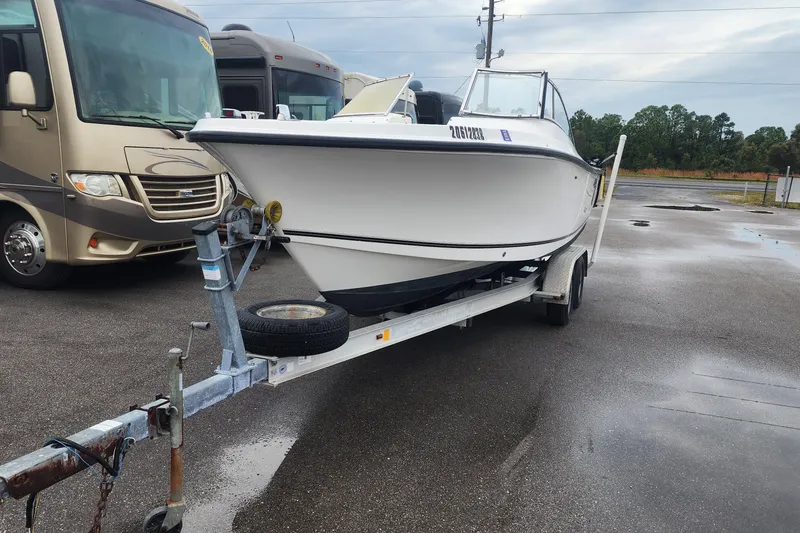 Slide: The Image of 2006 Mako 216 Dual Console boat on trailer, parked near RVs in a lot. - 6