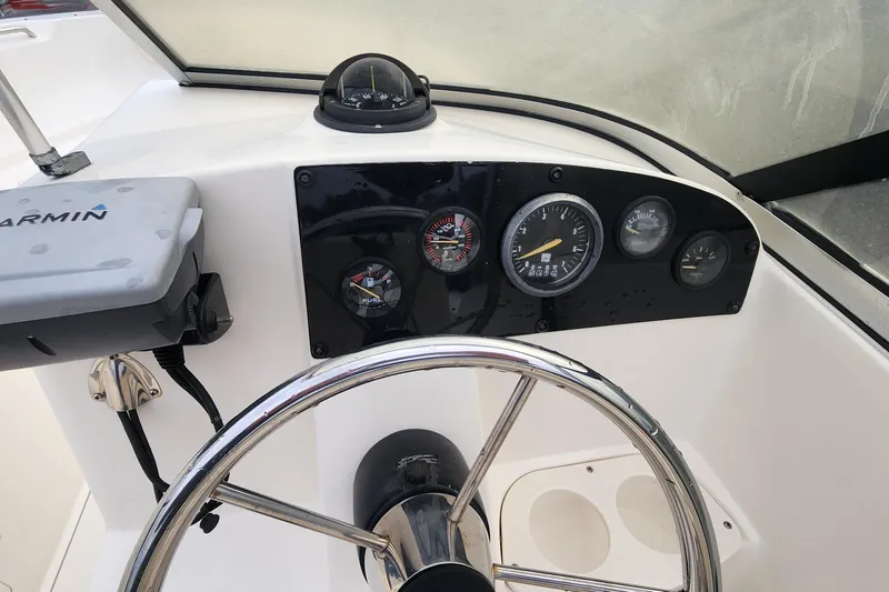 Slide: The Image of Steering console of a 2006 Mako 216 Dual Console boat with gauges and Garmin device. - 8