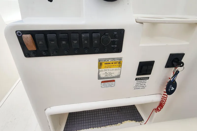 Slide: The Image of Control panel of a 2006 Mako 216 Dual Console boat with switches and warning labels. - 9