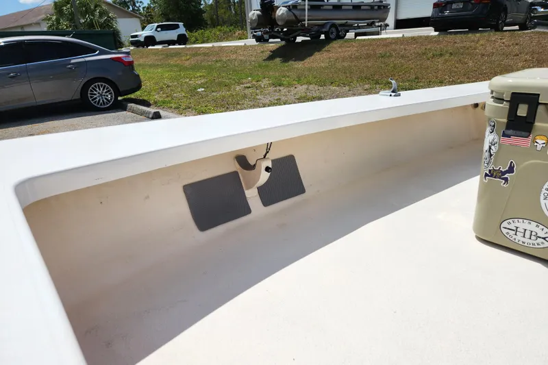 Slide: The Image of 2020 Spear Boatworks Evergladez interior with cooler and parked cars in background. - 10