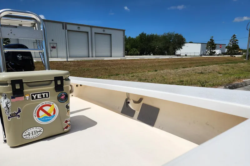 Slide: The Image of 2020 Spear Boatworks Evergladez with Yeti cooler, parked near industrial buildings under blue sky. - 12