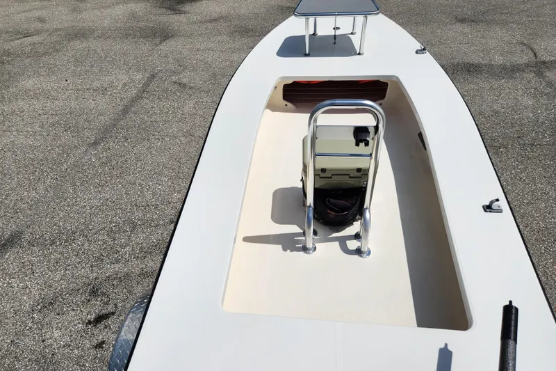 Slide: The Image of 2020 Spear Boatworks Evergladez deck with seating and storage, parked on pavement. - 14