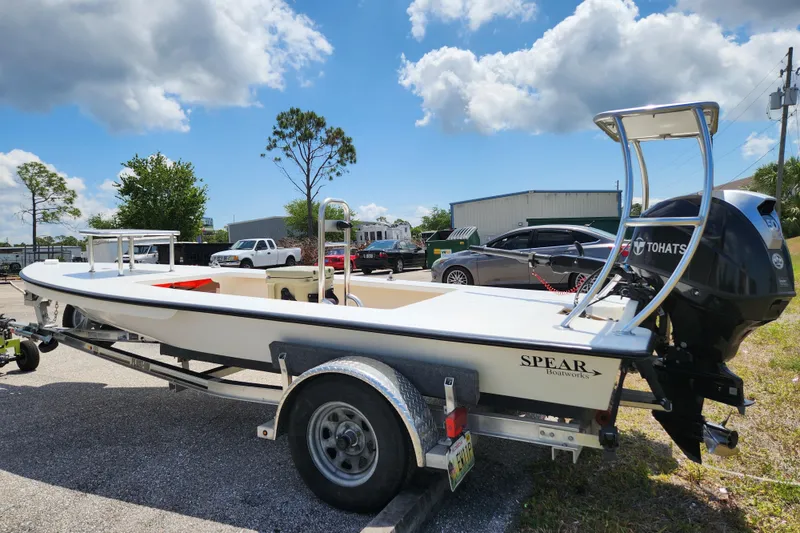 Slide: The Image of 2020 Spear Boatworks Evergladez on trailer with Tohatsu engine, parked outdoors. - 2
