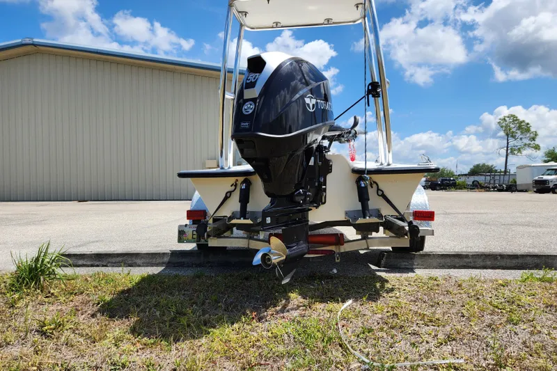 Slide: The Image of 2020 Spear Boatworks Evergladez with Tohatsu engine, parked outdoors under a clear blue sky. - 3
