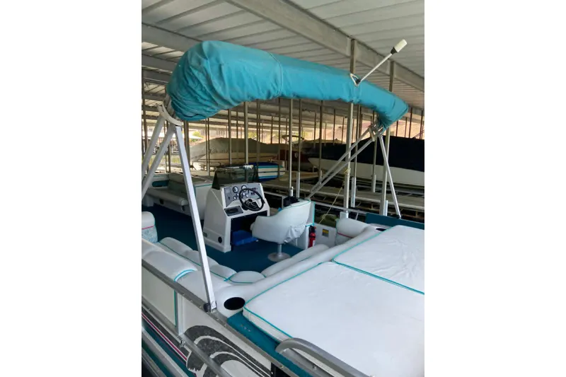 Slide: The Image of 1995 PlayCraft Powertoon 26 pontoon boat with teal canopy and spacious seating. - 12