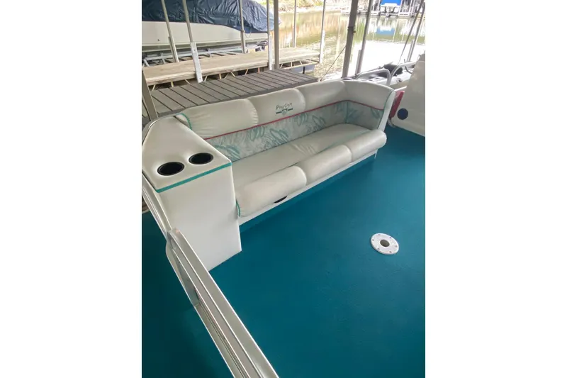 Slide: The Image of 1995 PlayCraft Powertoon 26 boat interior with teal carpet and cushioned seating. - 13