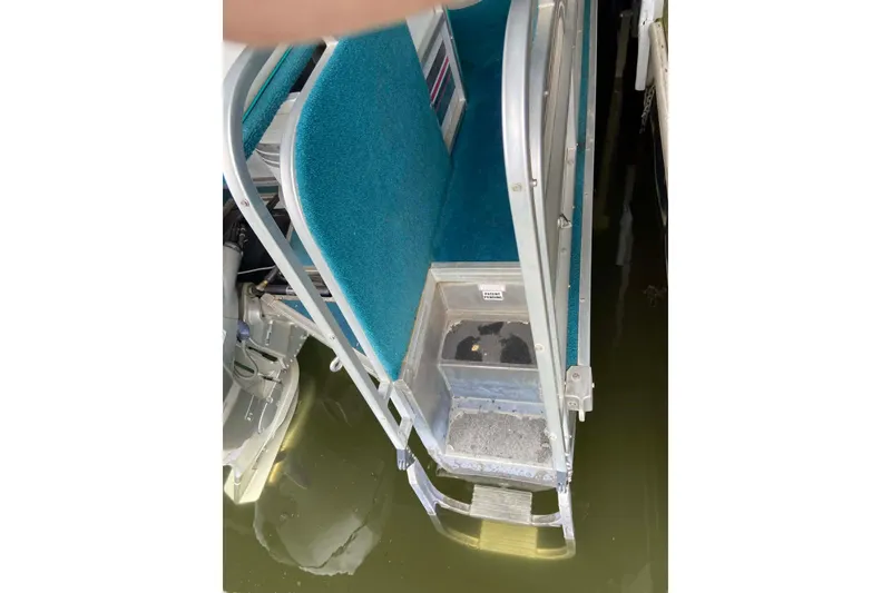 Slide: The Image of 1995 PlayCraft Powertoon 26 boat with teal seating and metal ladder over water. - 20