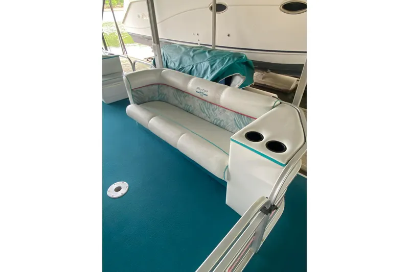 Slide: The Image of 1995 PlayCraft Powertoon 26 boat interior with teal carpet and cushioned seating. - 8