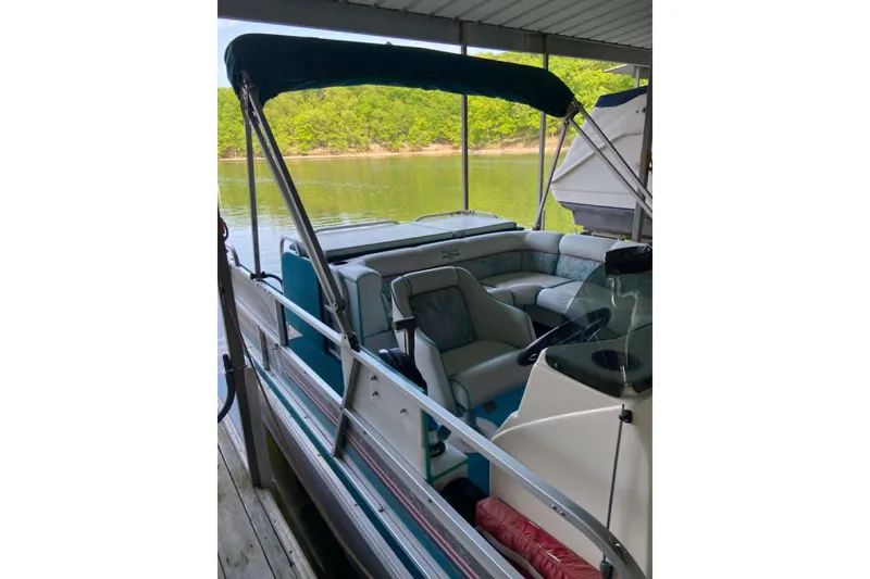 Slide: The Image of 1995 PlayCraft Powertoon 26 pontoon boat docked, featuring spacious seating and canopy. - 9