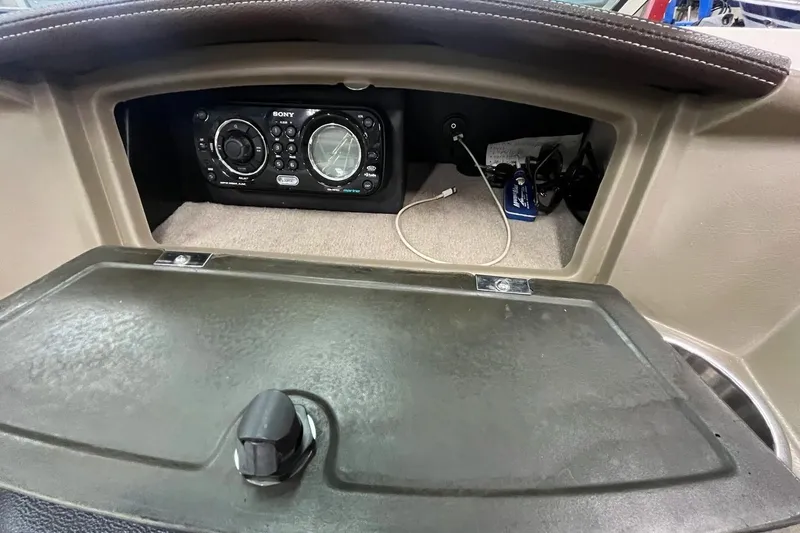Slide: The Image of 2012 Sea Ray SLX 230 dashboard with Sony stereo system and storage compartment. - 11