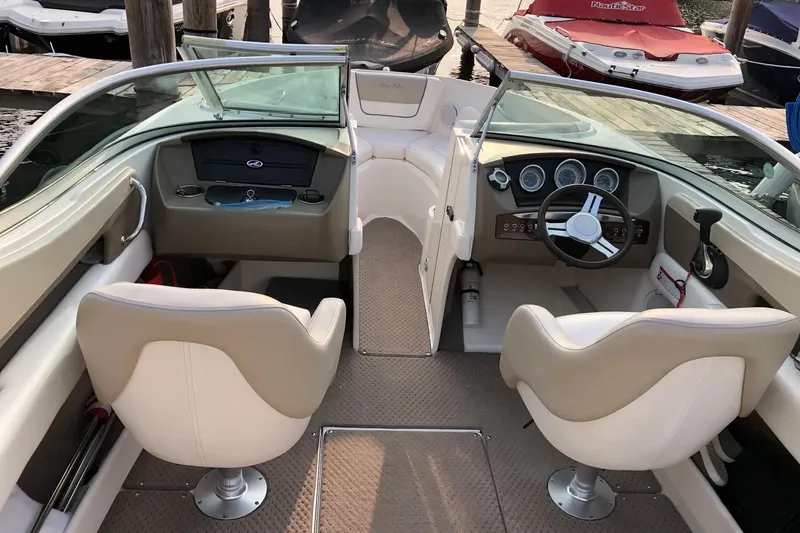 Slide: The Image of Interior of a 2012 Sea Ray SLX 230 boat with dual captain chairs and dashboard controls. - 13