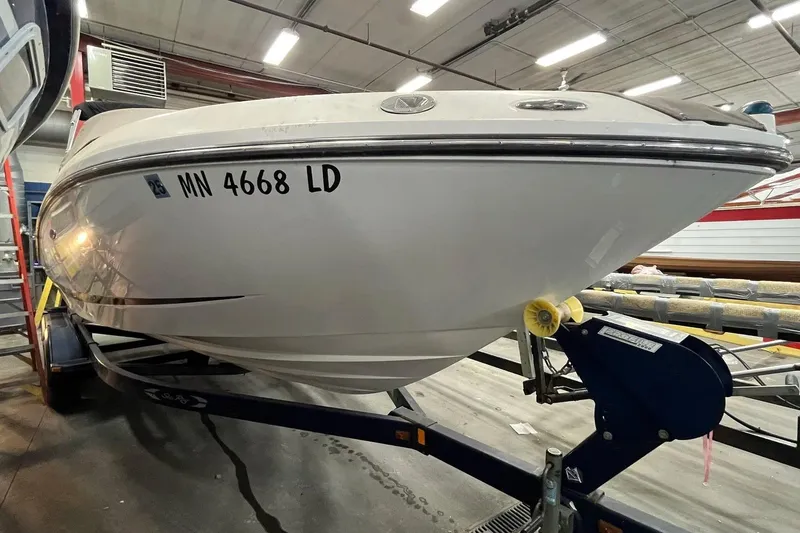 Slide: The Image of 2012 Sea Ray SLX 230 boat on trailer in indoor storage facility. - 16