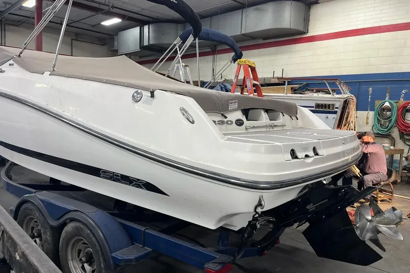 Slide: The Image of 2012 Sea Ray SLX 230 boat in a workshop, undergoing maintenance. - 18