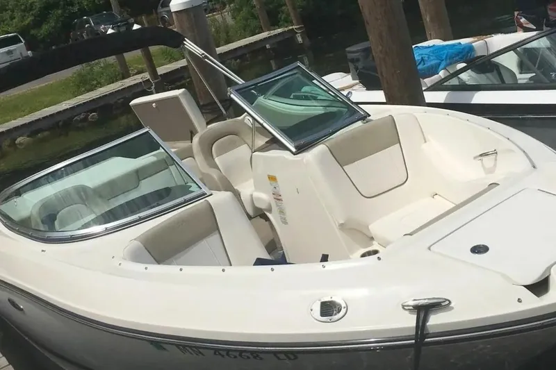 Slide: The Image of 2012 Sea Ray SLX 230 boat docked, featuring sleek design and spacious seating. - 2