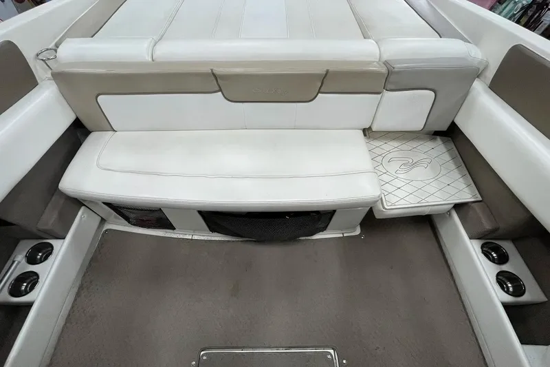 Slide: The Image of Interior of a 2012 Sea Ray SLX 230 boat, featuring white seating and carpeted flooring. - 27