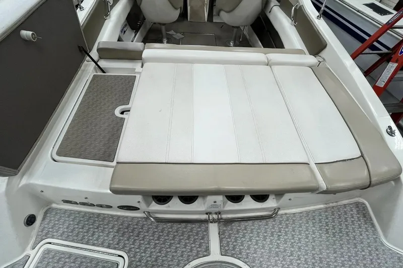 Slide: The Image of 2012 Sea Ray SLX 230 boat interior with beige and white seating and carpeted flooring. - 29