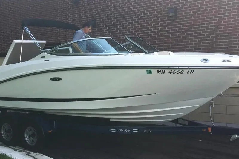 Slide: The Image of 2012 Sea Ray SLX 230 boat on trailer, parked near brick wall. - 3