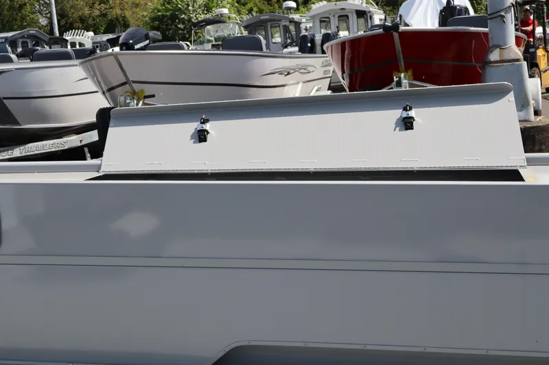 Slide: The Image of 2026 Smoker Craft Sportsman 1866 boat with open storage compartment, docked among other boats. - 10