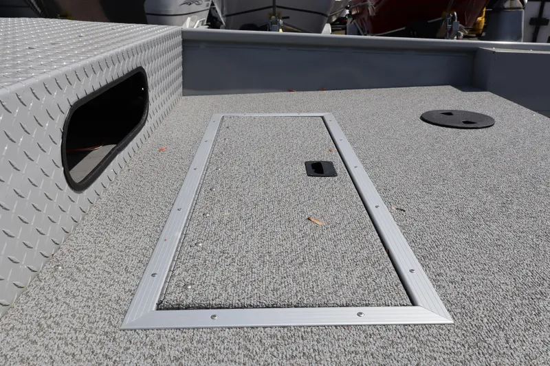 Slide: The Image of 2026 Smoker Craft Sportsman 1866 boat deck with storage hatch and textured surface. - 7