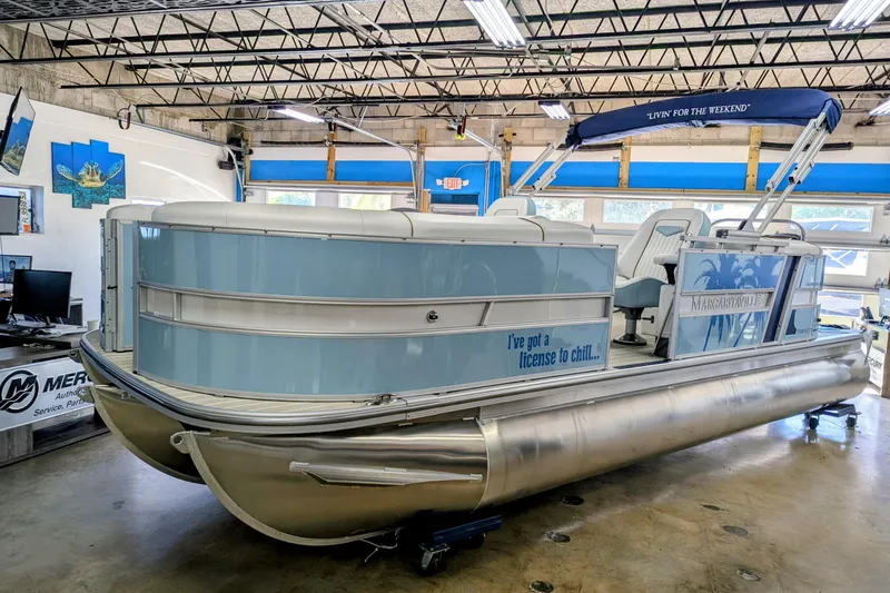 The Image of 2026 Trifecta CS 22RF pontoon boat in showroom, featuring "I've got a license to chill" text. - 0