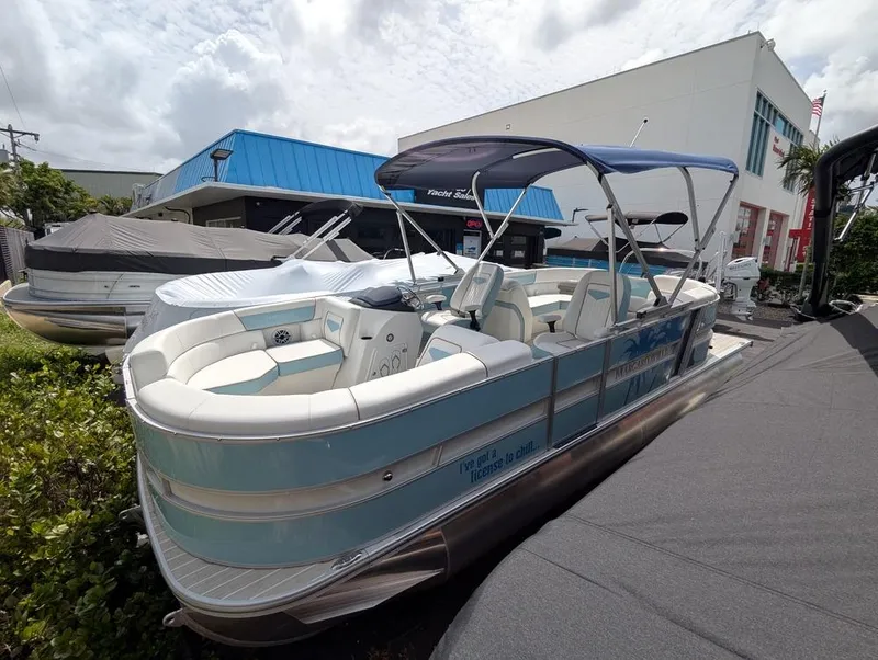 Slide: The Image of 2026 Trifecta CS 22RF pontoon boat with canopy, parked outdoors near dealership. - 4